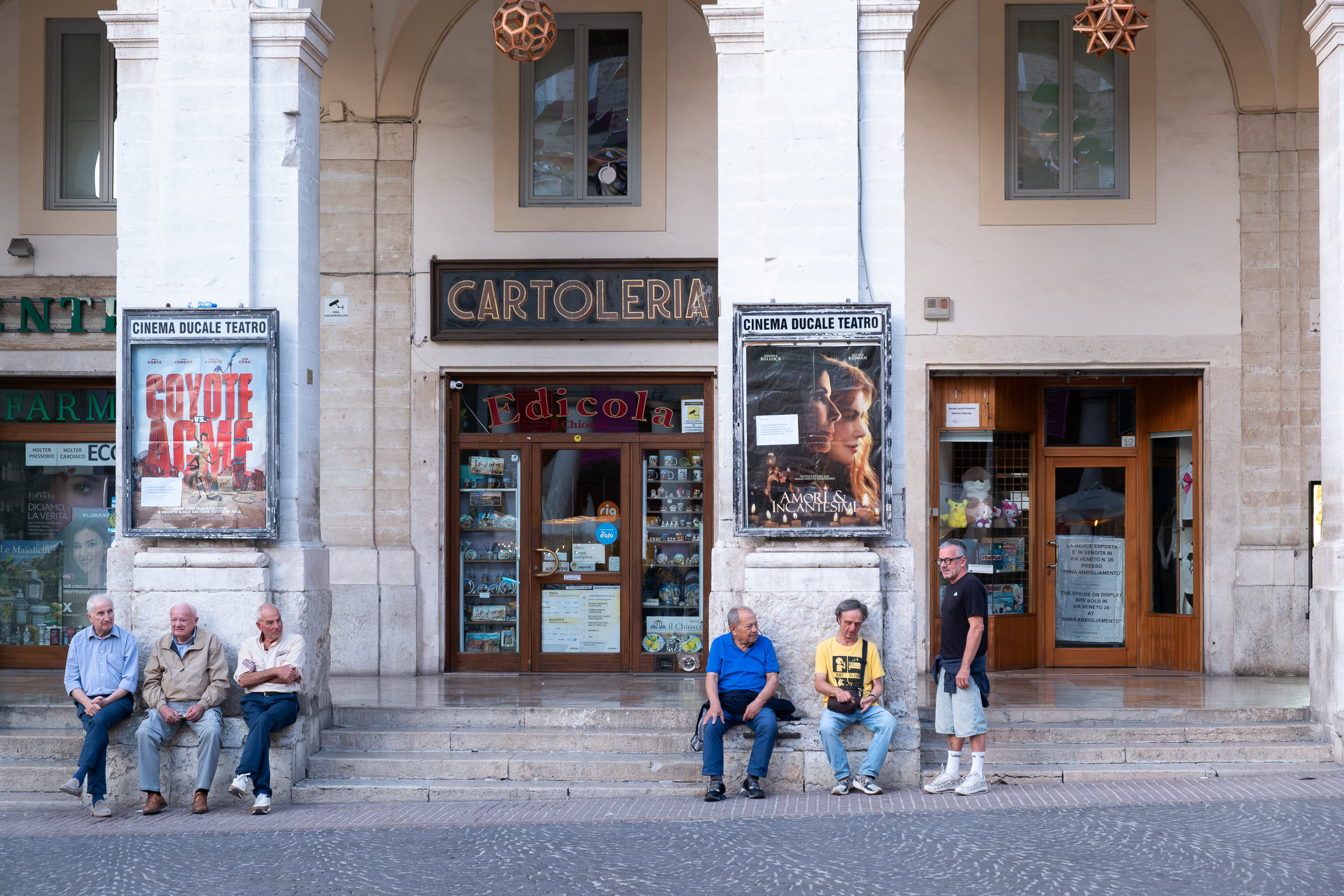 Unter den Arkaden – Einheimische vor dem Cinema Ducale